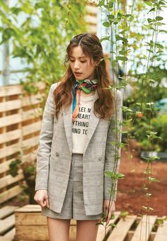 a young woman standing next to a plant