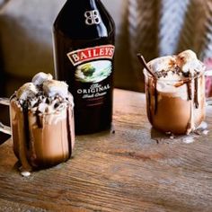 two glasses filled with ice cream next to a bottle of bailey's irish cream