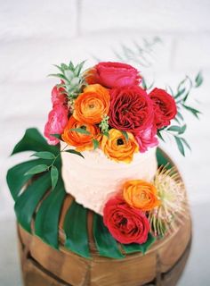 a wedding cake decorated with flowers and greenery