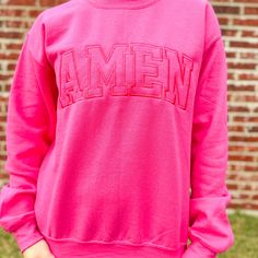 Amen - Hot Pink Embroidered Sweatshirt This sweatshirt is the perfect way to make a statement. Step out in style and be proud of your wardrobe! Trendy Embroidered Logo Sweater For Fall, Trendy College Sweatshirt With Embroidered Text, Trendy College Sweatshirt With Embroidered Graphics, Fall School Spirit Embroidered Sweatshirt, Fall Tops With Embroidered Text For School Spirit, School Spirit Embroidered Tops For Fall, School Spirit Tops With Embroidered Text For Fall, Fall School Spirit Tops With Embroidered Text, Fall Streetwear Sweatshirt With Embroidered Text