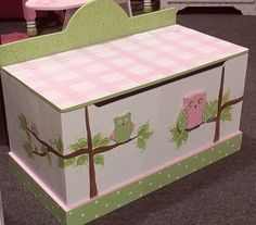 a pink and green toy chest with owls on it