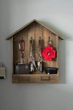 a wooden key holder with keys, wallets and other items hanging on the wall