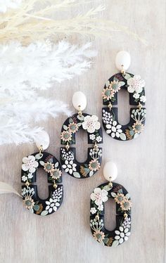 three black and white earrings with flowers on them