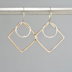 "These modern earrings feature two handmade geometric shapes. They are made from 14k yellow gold filled and sterling silver. They are given flat and hammered texture and a shiny finish. The ear wires are sterling silver.  Measures 1 1/2\" long including the ear wires." Hammered Rose Gold Sterling Silver Hoop Earrings, Rose Gold Hammered Sterling Silver Hoop Earrings, Cold Connections, Herkimer Diamond Earrings, Geometric Hoop Earrings, Shiny Objects, Earrings Design, Earrings Inspiration, Wood Earrings