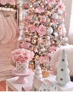 a white christmas tree with pink flowers and ornaments