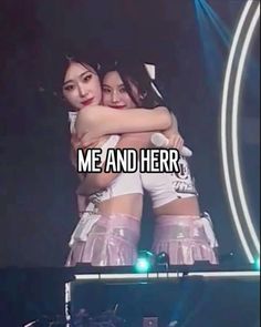 two girls hugging each other on stage with the words me and her in front of them