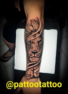 a man with a lion and cross tattoo on his arm is shown in this photo