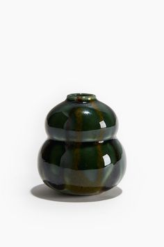 two green vases sitting side by side on a white surface, one is black and the other is green