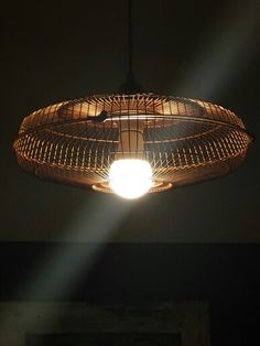 a light that is hanging from a ceiling in a dark room with a fan on it