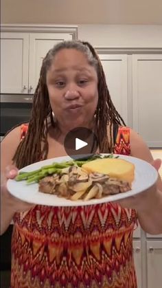 a woman holding a plate with food on it