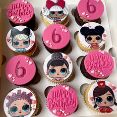 cupcakes with pink frosting and cartoon characters on them in a cardboard box