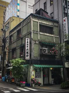 an old building with many windows and balconies on the top floor, in front of other buildings