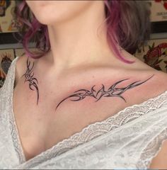 a woman with pink hair has a tattoo on her chest