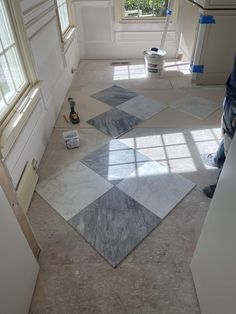 a man is standing in the middle of a room with several tiles on the floor