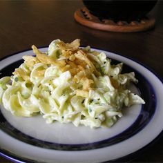 a white and blue plate topped with pasta salad next to a bowl of potato chips