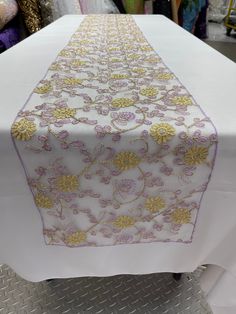 the table is covered with white and gold linens, which are embellished with flowers