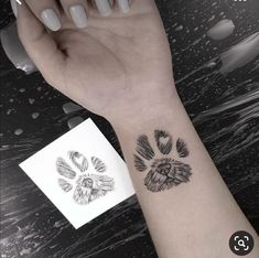 a woman's arm with a tattoo on it that has an animal paw in the middle