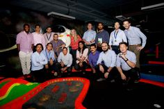 a group of men standing next to each other in front of a fake space rocket