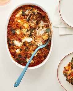 a white bowl filled with food next to two plates