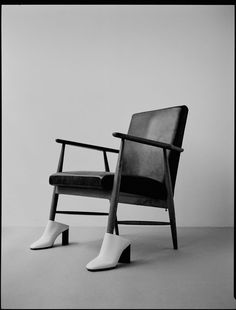 a black and white photo of a pair of shoes sitting on a chair