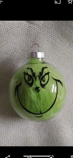 a green glass ornament with a face drawn on it