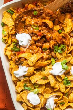 a casserole dish filled with nachos and meat