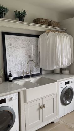 a washer and dryer in a laundry room with clothes hanging on the rack