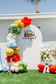 balloons are arranged in the shape of an arch on top of a sign that reads two twenty and beyond