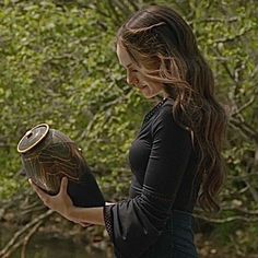 a woman holding a vase in her hands