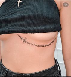 a woman with a cross tattoo on her side and a chain around her waist is shown