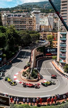 an aerial view of a race track with cars driving on it and people standing around