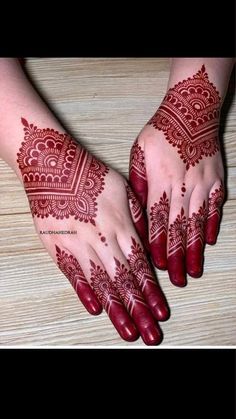 two hands with henna tattoos on them, one is red and the other is white