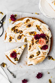 a piece of cake with flowers on it next to a pair of scissors and a knife