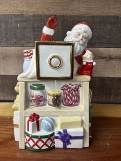 a santa clause figurine sitting on top of a shelf filled with christmas items