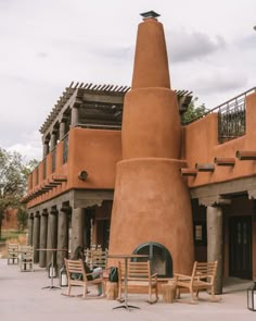 an adobe - style building with tables and chairs outside