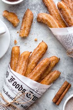 cinnamon sugar churros and coffee on a table with newspaper wrappers next to them