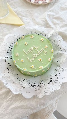 a green cake sitting on top of a white doily