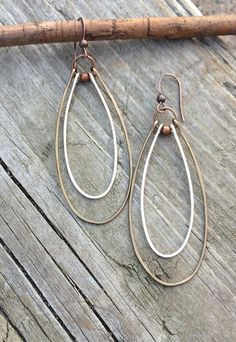 Hammered copper and silver long hoop earrings.These super light weight earrings are made with thin hammered hoops of silver and antiqued copper. Both of these antiqued metals work beautifully together to create a rustic, classic elegance. Product overview:* Made with antiqued copper and antiqued silver plated, hammered wire* Approx. 2.5" in length* Very light-weight and versatile* Hypoallergenic ear wires* Also available in all silver, please see link belowYou may also like:https://www.etsy.com/ Copper Gifts, Bijoux Fil Aluminium, Mixed Metal Earrings, Mixed Metal Jewelry, Fine Silver Jewelry, Silver Jewelry Earrings, Jewelry Style, Leaf Jewelry, Silver Jewelry Rings