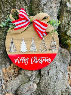 a christmas ornament hanging on a tree with red and white ribbon around it