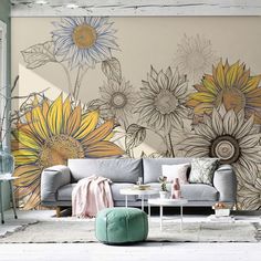 a living room with sunflowers painted on the wall and a couch in front of it