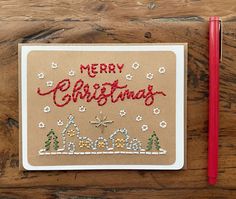 a christmas card with the words merry christmas written in red and green on it next to a pencil