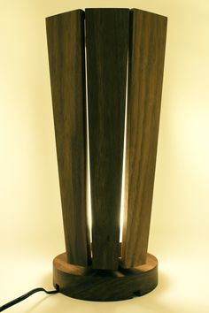 a lamp that is on top of a wooden stand with two lights in the middle