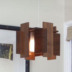 the light fixture is made out of wood and has a square shaped design on it