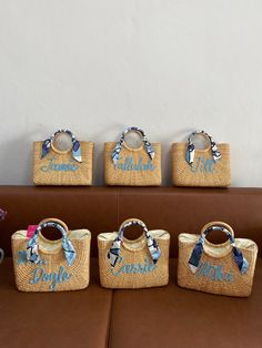 four personalized straw bags sitting on top of a couch