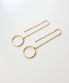 "Hand forged circle pendants are suspended from delicate gold chain threaders with our NEW Genevieve Circle Threader Earrings. This weightless, modern design offers lots of movement, and the hammered circles reflect light from all angles. MATERIALS: 14k gold filled circle charms and chain threaders MEASUREMENTS: 2.25\" length | 0.6\" width ORIGIN: Handcrafted in Florida STYLE: GNVE02 Receive 15% off your next order, preview new releases and gain early access to sales when you sign up for our VIP 14k Gold Earrings With Adjustable Chain, Gold Earrings With Delicate Chain, Gold Round Earrings With Delicate Chain, 14k Gold Filled Yellow Gold Open Circle Jewelry, Dainty Yellow Gold Round Linear Earrings, Gold Round Threader Earrings For Everyday, Gold Small Hoop Jewelry With Adjustable Chain, Gold Jewelry With Adjustable Small Hoop Chain, Dainty Round Earrings With Delicate Chain