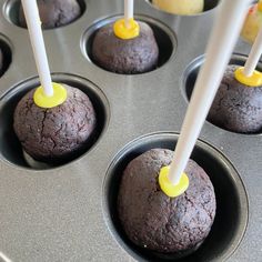 chocolate cupcakes with yellow icing sitting in a muffin tin, ready to be eaten