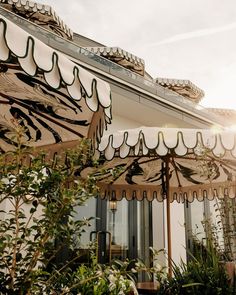 the sun is shining on an outdoor patio area with umbrellas and potted plants