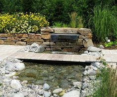 a small pond surrounded by rocks and flowers