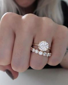 a woman's hand with two engagement rings on it