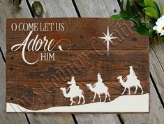 a wooden sign that says o come let us adore him with three wise men on horseback